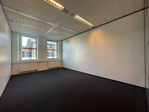 Leeg, modern kantoor met twee ramen en witte wanden in bedrijfsverzamelgebouw De Wel.